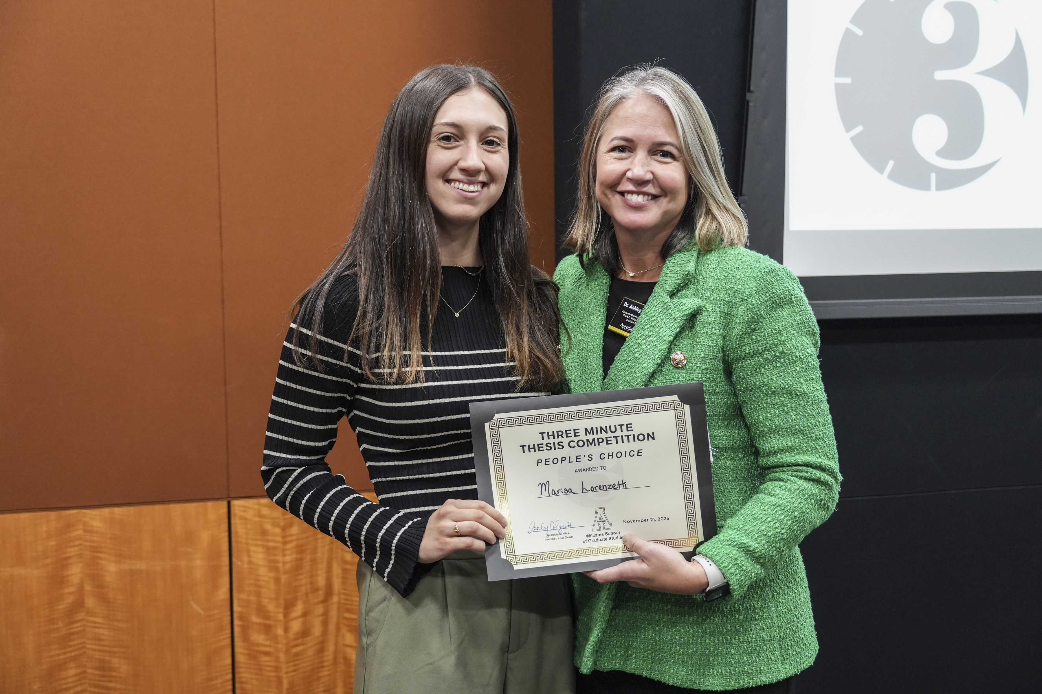 Marissa Lorenzetti, 3MT People's Choice Award winner receives her award from Dr. Colquitt.
