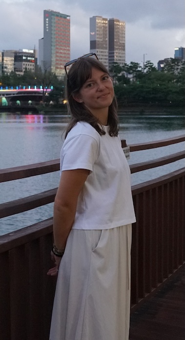 Taylor Ward smiles with a river and cityscape in the background.